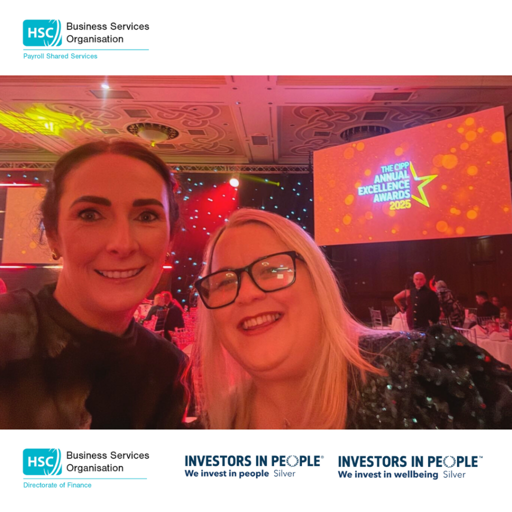Two women smiling at a camera with a large screen behind them with the CIPP Logo
